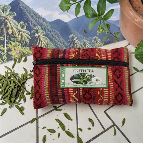 House of Nepal green tea in a reusable, handmade, red, yellow, and pink patterned pouch with a zipper and black cord. Contains 25 tea bags.