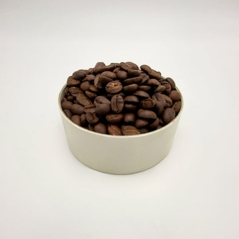 House of Nepal Jalpa Gold Arabica coffee beans in a white paper container, medium-dark roast.
