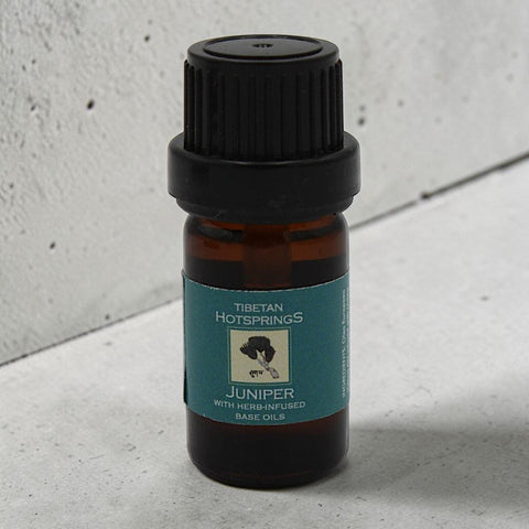 House of Nepal Tibetan Hotsprings Juniper essential oil in a small amber glass bottle with a black cap and teal label.