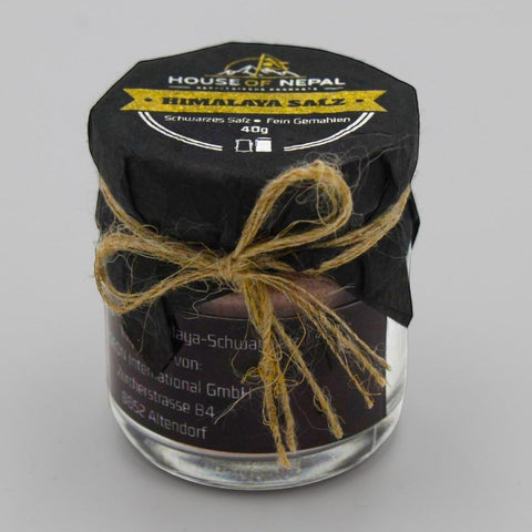 House of Nepal Kala Namak Himalaya Salz, fine ground black salt in a glass jar with black paper lid tied with twine.