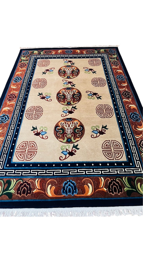 House of Nepal Karnali Teppich 140x200 cm, beige mit Ornamentmuster, Medaillons, Vögeln und Shou-Symbolen, handgeknüpft aus tibetischer Schafwolle.