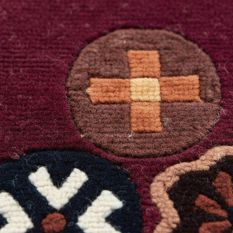 House of Nepal maroon Tibetan wool rug with circular motifs in brown, orange, and cream. Hand-knotted, 60x90cm.