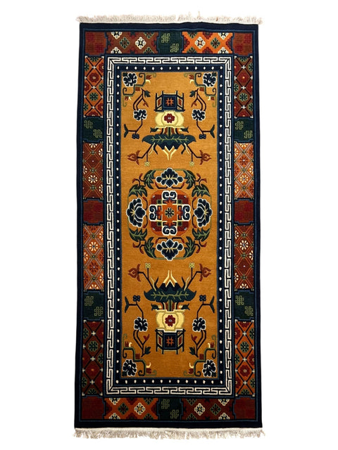 House of Nepal Nepalesischer Pasang Vessel Teppich 90x180 cm, handgeknüpft aus tibetischer Schafwolle, mit Blumenmuster und geometrischen Bordüren in Gelb, Blau und Orange.