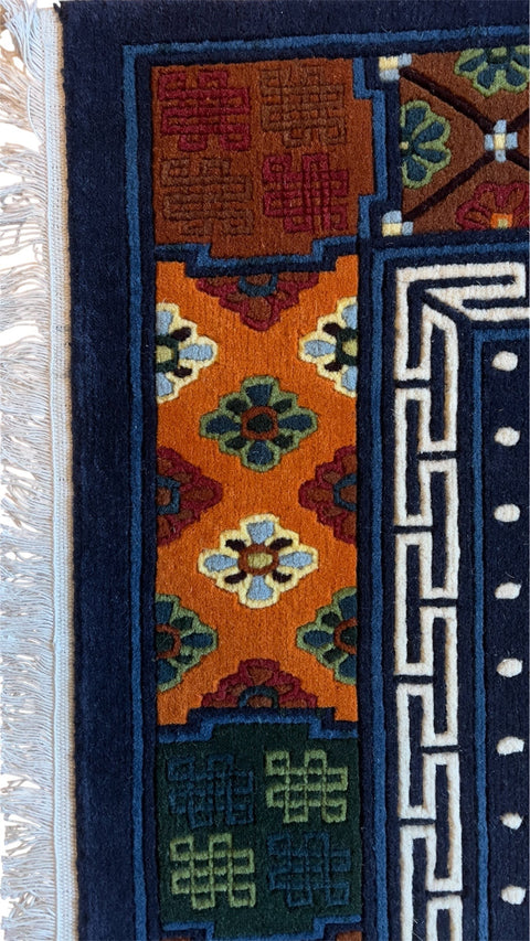 House of Nepal Nepalesischer Pasang Teppich 90x180 cm, handgeknüpft aus tibetischer Schafwolle mit Blumenmuster und geometrischen Bordüren in Gelb, Blau und Orange.