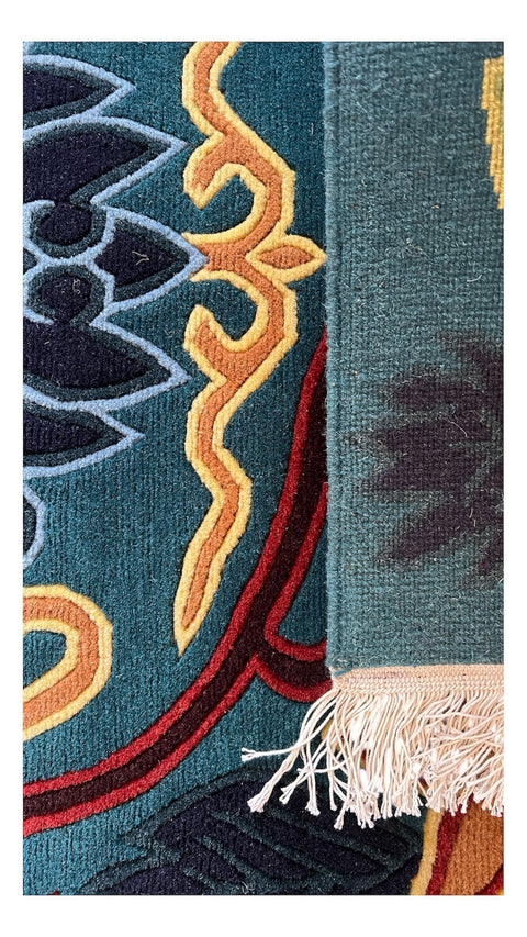 House of Nepal Nepalesischer Teppich 173x247 cm aus tibetischer Schafwolle mit Blumenmuster in Blau, Braun, Schwarz und Grün.