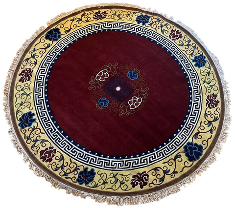 House of Nepal Runder Teppich aus tibetischer Schafwolle mit traditionellem Muster, Fransen und rotem Zentrum.