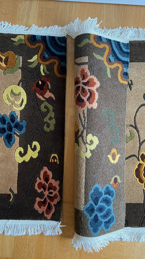House of Nepal Petals of Autumn Teppich 60 x 90 cm, handgeknüpft aus 100% tibetischer Schafwolle mit floralem Muster in Braun, Blau und Rosa.