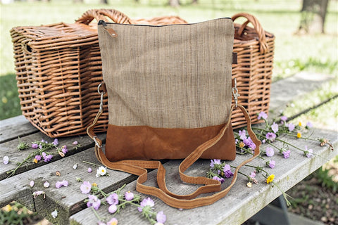 House of Nepal beige woven nettle and brown leather foldover crossbody bag with adjustable strap.