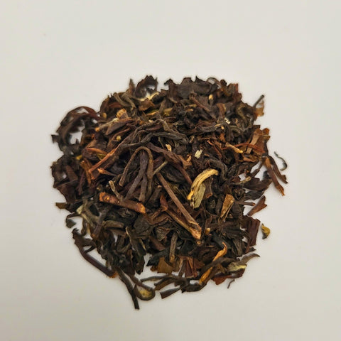 House of Nepal Ilam black tea leaves, dark brown with hints of gold, loose leaf, aromatic and malty.
